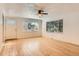 Bright living room with hardwood floors, ceiling fan, and large windows offering natural light at 695 S Quitman St, Denver, CO 80219