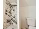 Modern tiled shower featuring elegant marble-style walls, sleek fixtures, and a convenient built-in shower niche at 695 S Quitman St, Denver, CO 80219