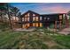 The backyard has a stone patio, large windows, and stairs leading up to a wooden balcony and fenced yard at 26452 Wolverine Trl, Evergreen, CO 80439