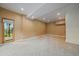 A spacious basement featuring neutral carpeting and a door to the outside at 26452 Wolverine Trl, Evergreen, CO 80439