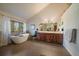 Bathroom featuring a soaking tub, dual sink vanity, and a large window that provides natural light at 26452 Wolverine Trl, Evergreen, CO 80439