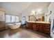 Bathroom featuring a soaking tub, dual sink vanity, and a large window that provides natural light at 26452 Wolverine Trl, Evergreen, CO 80439