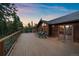 Spacious wooden deck with seating and great views of the mountains in the background provides an outdoor oasis at 26452 Wolverine Trl, Evergreen, CO 80439