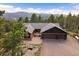 Spacious home with mountain views, a large driveway, and a peaceful koi pond creates inviting curb appeal at 26452 Wolverine Trl, Evergreen, CO 80439