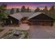 Home featuring a three-car garage, mountain views, inviting curb appeal, and rock garden with pond at 26452 Wolverine Trl, Evergreen, CO 80439
