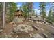 Unique rustic cabin nestled among the trees, offering a secluded retreat with natural rock formations at 26452 Wolverine Trl, Evergreen, CO 80439