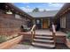 Inviting front porch with ample seating, wood detail, and planters with fresh flowers adds warmth at 26452 Wolverine Trl, Evergreen, CO 80439