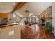 Spacious, open-concept living room with large windows, stone fireplace, and hardwood flooring brings in natural light at 26452 Wolverine Trl, Evergreen, CO 80439