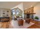 Cozy living room featuring hardwood floors, stone fireplace, large windows and vaulted ceilings offers a warm space at 26452 Wolverine Trl, Evergreen, CO 80439