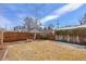 Spacious backyard with lawn, fence, some snow cover, and a stone bench at 1804 S Corona St, Denver, CO 80210