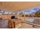 Covered back patio with a grill, and a natural wood dining table and chairs at 1804 S Corona St, Denver, CO 80210