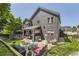 Expansive backyard featuring a covered patio, brick seating area, lush lawn, and attractive home exterior at 10330 Lions Path, Lone Tree, CO 80124
