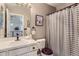 Neutral bathroom with a white tiled counter, modern faucet, and classic gray and white shower curtain at 10330 Lions Path, Lone Tree, CO 80124