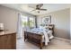 Bedroom with a ceiling fan, light gray walls, and windows dressed with flowing white curtains at 10330 Lions Path, Lone Tree, CO 80124
