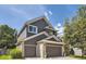 Two-story home showcasing gray siding, brick accents, a two-car garage, and a well-maintained lawn at 10330 Lions Path, Lone Tree, CO 80124