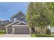 Charming two-story home with brick accents, a two-car garage, and mature landscaping on a sunny day at 10330 Lions Path, Lone Tree, CO 80124