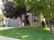 Beautiful home featuring a brick facade, well-maintained lawn, and mature trees enhancing curb appeal at 10330 Lions Path, Lone Tree, CO 80124
