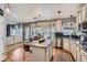 Bright, open kitchen with granite island, stainless appliances, white cabinets, and adjacent living area with large windows at 10330 Lions Path, Lone Tree, CO 80124