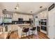 Modern kitchen with white cabinetry, granite countertops, stainless steel appliances, and an island with seating at 10330 Lions Path, Lone Tree, CO 80124