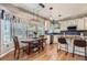 Inviting eat-in kitchen featuring a dining table near a bay window, white cabinets, and an island with bar stools at 10330 Lions Path, Lone Tree, CO 80124