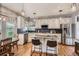 Well-lit kitchen features white cabinets, stainless steel appliances, granite counters, and an island with bar seating at 10330 Lions Path, Lone Tree, CO 80124