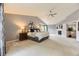 Spacious main bedroom with a fireplace, vaulted ceilings, a ceiling fan, and views of the en-suite at 10330 Lions Path, Lone Tree, CO 80124