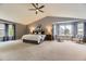 Spacious main bedroom boasting vaulted ceilings, a ceiling fan, and large windows with decorative curtains at 10330 Lions Path, Lone Tree, CO 80124