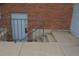 Stairs lead to a basement door with a metal railing and brick wall at 7665 E Eastman Ave # 111A, Denver, CO 80231