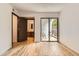 Bedroom view showcasing an attached bath and balcony access with wood-look floors at 7665 E Eastman Ave # 111A, Denver, CO 80231