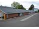 Long, multi-unit brick building featuring a dark roof and gray siding against a parking area at 7665 E Eastman Ave # 111A, Denver, CO 80231