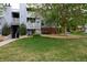 View of the exterior of the building on a grassy lawn with mature landscaping at 7665 E Eastman Ave # 111A, Denver, CO 80231