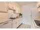 Kitchen area with white cabinets, granite countertops, and black and white tile flooring at 7665 E Eastman Ave # 111A, Denver, CO 80231