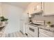 Bright kitchen area with appliances, granite countertops, and white cabinetry at 7665 E Eastman Ave # 111A, Denver, CO 80231