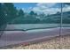 Enclosed tennis courts with a green mesh fence and gravel surrounding at 7665 E Eastman Ave # 111A, Denver, CO 80231
