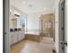 Bathroom with double sink vanity, soaking tub, and glass-enclosed shower at 3529 Xanthia Ct, Denver, CO 80238