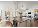 Open-concept kitchen featuring a large island with granite countertops and pendant lighting at 3529 Xanthia Ct, Denver, CO 80238