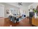 Bright living room boasts a ceiling fan, hardwood floors, fireplace, and plentiful windows for an airy ambiance at 3529 Xanthia Ct, Denver, CO 80238