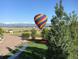 Scenic view of a colorful hot air balloon over a neighborhood with mountains in the background at 4939 Silver Feather Cir, Broomfield, CO 80023