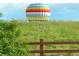 Hot air balloon behind a wooden fence in a field of flowers at 4939 Silver Feather Cir, Broomfield, CO 80023