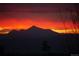 Fiery sunset over silhouetted mountains, creating a vibrant and striking image at 4939 Silver Feather Cir, Broomfield, CO 80023