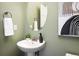 Stylish powder room with pedestal sink, decorative mirror, and fresh green paint at 4939 Silver Feather Cir, Broomfield, CO 80023