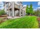 Lush backyard featuring green lawn and patio with stairs to upper deck at 676 Fossil Bed Cir, Erie, CO 80516