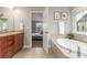This bathroom features a soaking tub and vanity with wood cabinets at 676 Fossil Bed Cir, Erie, CO 80516