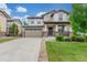 Charming two-story home featuring a manicured lawn and a welcoming front porch with stone accents at 676 Fossil Bed Cir, Erie, CO 80516