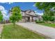 Charming two-story home featuring a manicured lawn and a welcoming front porch with stone accents at 676 Fossil Bed Cir, Erie, CO 80516