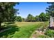 Expansive backyard featuring lush green grass, mature trees, and an outdoor living space on a spacious deck at 1473 E 130Th Dr, Thornton, CO 80241