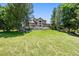 Large backyard featuring mature trees, lush green grass, and a spacious deck for outdoor enjoyment at 1473 E 130Th Dr, Thornton, CO 80241