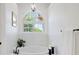 Bright bathroom featuring a large soaking tub with tiled backsplash and modern chandelier at 1473 E 130Th Dr, Thornton, CO 80241