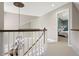 Hallway with wooden banister leads to bedroom with view of vaulted ceilings and modern chandelier at 1473 E 130Th Dr, Thornton, CO 80241