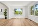 Bright living room with hardwood floors and large windows overlooking trees at 1473 E 130Th Dr, Thornton, CO 80241